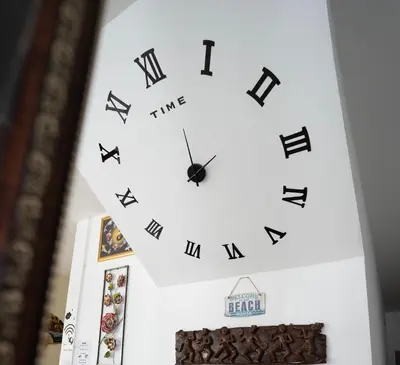 a clock with roman numerals on a wall at OK Phuket in Kata Beach
