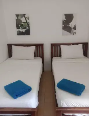 two beds in a room with blue towels on them at Blanco Central in Phi Phi Don