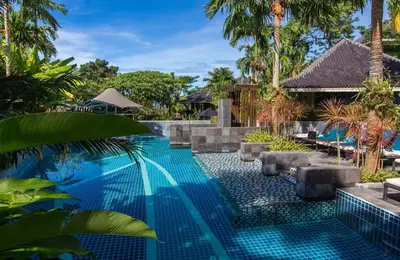 a swimming pool in a resort with palm trees at Mandarava Resort and Spa, Karon Beach in Karon Beach