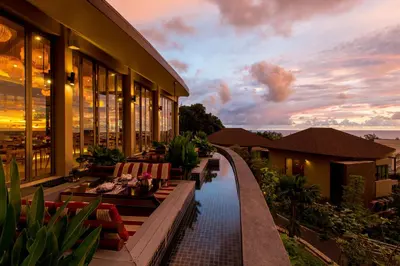 a building with benches and a pool in front of it at Mandarava Resort and Spa, Karon Beach in Karon Beach