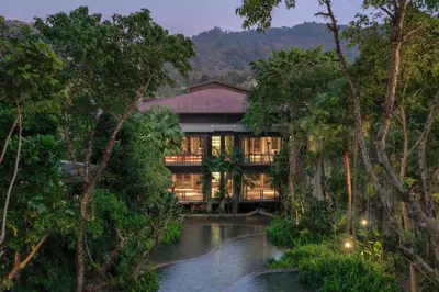 a house in the middle of a forest with a river at Pullman Phuket Arcadia Naithon Beach in Nai Thon Beach