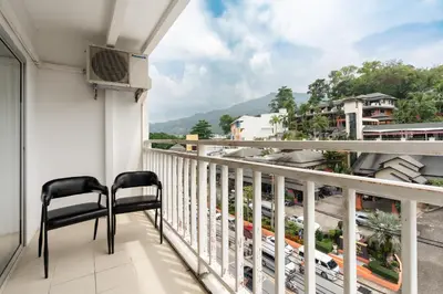 a balcony with two chairs and a view of a city at The Eden Park in Patong Beach