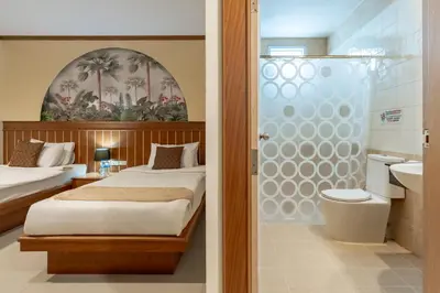 a bedroom with a bed and a bathroom with a shower at The Eden Park in Patong Beach