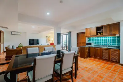 a kitchen and living room with a table and chairs at The Sand Beach Apartment in Nai Harn Beach