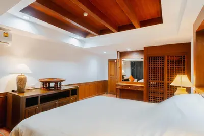 a bedroom with a large white bed and a desk at The Sand Beach Apartment in Nai Harn Beach