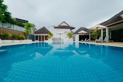 a swimming pool in a villa with blue water at The Sand Beach Apartment in Nai Harn Beach
