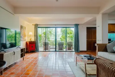 a living room with a couch and a table at The Sand Beach Apartment in Nai Harn Beach