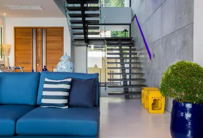 a blue couch in a living room with stairs at Villa Momo Private Pool near Kata Beach in Kata Beach