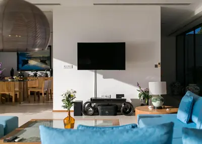 a living room with a television and blue chairs at The heights Penthouse Ocean view A11 Near Kata Beach in Kata Beach