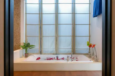 a bathroom with a bath tub with a large window at Kata Gardens Penthouse sea view 4C near Kata Noi Beach in Kata Beach