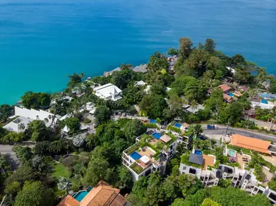 an aerial view of a house on a hill next to the ocean at Kata Gardens Penthouse sea view 4C near Kata Noi Beach in Kata Beach