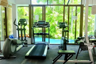 a gym with treadmills and machines in front of a window at Kata Gardens Penthouse sea view 4C near Kata Noi Beach in Kata Beach