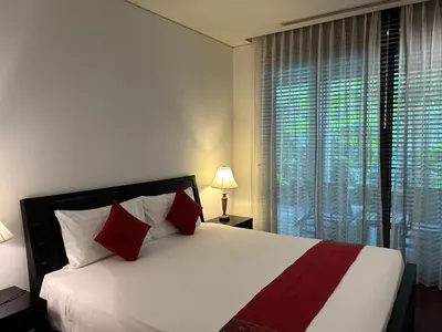 a bedroom with a large white bed with red pillows at Kata Gardens Luxury Apartment 8B at Kata Noi Beach in Kata Beach