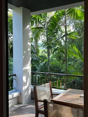 a patio with a table and chairs and trees at Kata Gardens Luxury Apartment 8B at Kata Noi Beach in Kata Beach