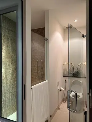 a bathroom with a shower and a toilet and a glass door at Kata Gardens Luxury Apartment 8B at Kata Noi Beach in Kata Beach