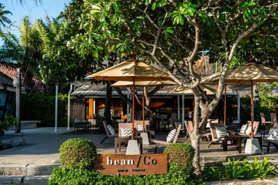 a sign in front of a restaurant with chairs and umbrellas at SAii Phi Phi Island Village in Phi Phi Don