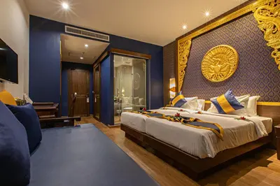 a bedroom with a king sized bed and blue walls at Kata Palm Resort - SHA Plus in Kata Beach
