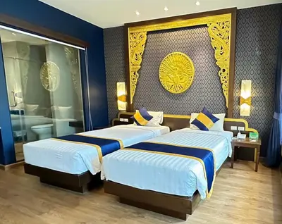 two beds in a room with blue and yellow at Kata Palm Resort - SHA Plus in Kata Beach