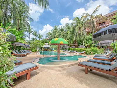 a pool with lounge chairs and an umbrella at a resort at Kata Palm Resort - SHA Plus in Kata Beach