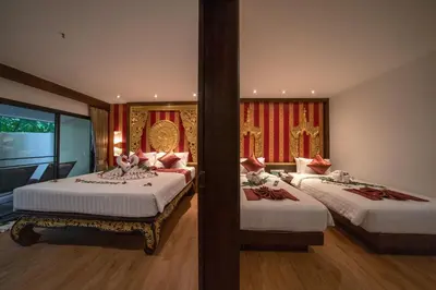 a bedroom with two beds with red curtains at Kata Palm Resort - SHA Plus in Kata Beach