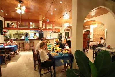 a group of people sitting at tables in a restaurant at Ya Nui Resort - SHA EXTRA Plus in Rawai Beach