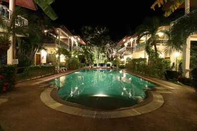 a swimming pool in front of a hotel at night at Ya Nui Resort - SHA EXTRA Plus in Rawai Beach