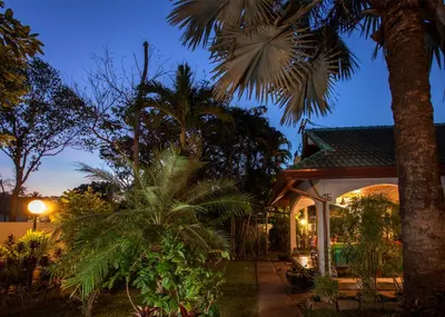 a house with palm trees in the night at Ya Nui Resort - SHA EXTRA Plus in Rawai Beach