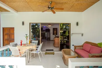 a living room with a ceiling fan and a table and chairs at Ya Nui Resort - SHA EXTRA Plus in Rawai Beach