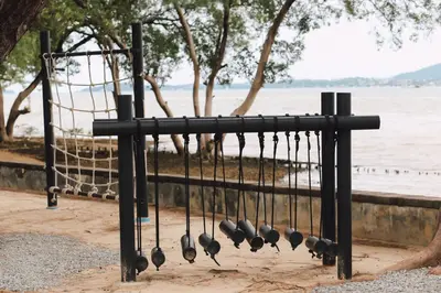a group of baseballoons hanging on a rack by the water at The Mangrove Phuket by Blu Monkey in Panwa Beach
