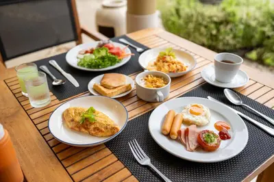 a table with plates of breakfast food on it at The Mangrove Phuket by Blu Monkey in Panwa Beach