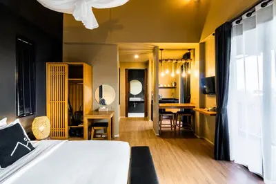 a bedroom with a bed and a desk with chairs at The Mangrove Phuket by Blu Monkey in Panwa Beach