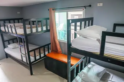 a room with three bunk beds and a window at Blanco Beach Bar Hostel in Phi Phi Don