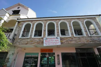a brick building with a sign for a room for rent at Baan Malee in Phuket Town