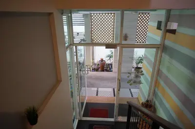 a view of a hallway from a house with a glass door at Baan Malee in Phuket Town