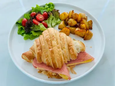 a white plate of food with a sandwich and vegetables at The Kiri Villas Resort in Thalang