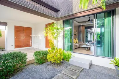 a home with a pivot door and a porch at The Kiri Villas Resort in Thalang