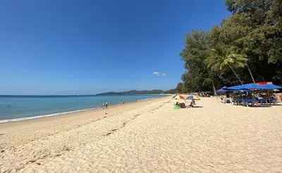 a beach with people and umbrellas and the ocean at Studio at Kris Condo walk to Bangtao beach 2304 in Bang Tao Beach