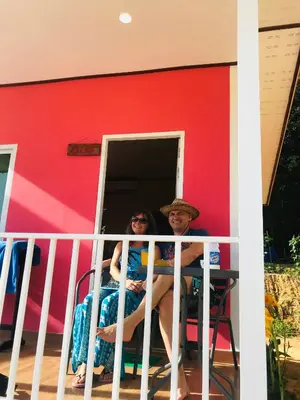 a man and woman sitting at a table in front of a house at Koh Yao Candy House in Ko Yao Yai