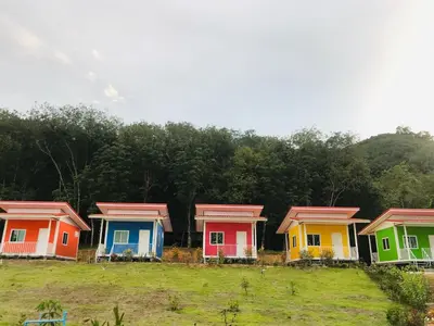 a row of colorful homes in a field at Koh Yao Candy House in Ko Yao Yai