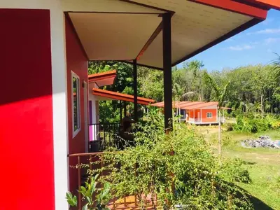 a view from the porch of a red and white house at Koh Yao Candy House in Ko Yao Yai