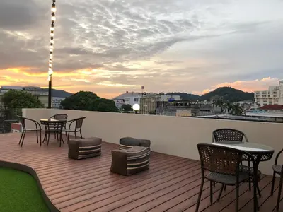 a deck with chairs and tables on a balcony at Peranakan Boutique Hotel - SHA Plus in Phuket Town