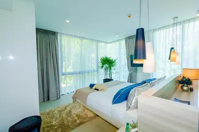 a bedroom with a large bed and a large window at Oceanstone by Holy Cow, 2-BR, 75 m2, garden view in Bang Tao Beach