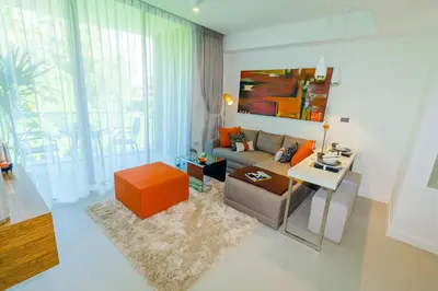 a living room with a couch and a table at Oceanstone by Holy Cow, 2-BR, 75 m2, garden view in Bang Tao Beach