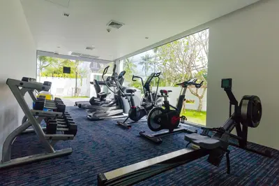 a gym with several treadmills and elliptical machines at Oceanstone by Holy Cow, 2-BR, 75 m2, garden view in Bang Tao Beach