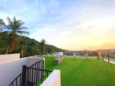 a balcony of a house with a grass yard at Twin Villas Seaview Kata in Kata Beach