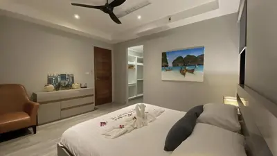a bedroom with a bed and a chair in it at Twin Villas Seaview Kata in Kata Beach