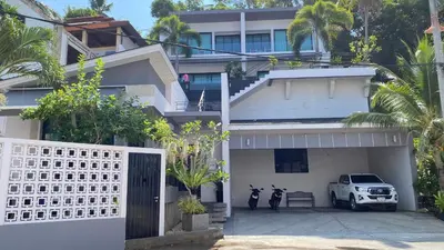 a white house with two motorcycles parked in front of it at Twin Villas Seaview Kata in Kata Beach