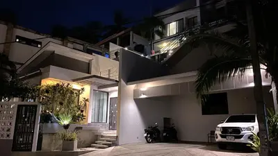a white car parked in front of a building at night at Twin Villas Seaview Kata in Kata Beach