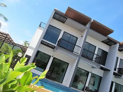 a house with a swimming pool in front of it at Alphabeto Resort in Nai Harn Beach