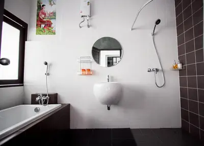 a bathroom with a tub and a sink and a mirror at Alphabeto Resort in Nai Harn Beach